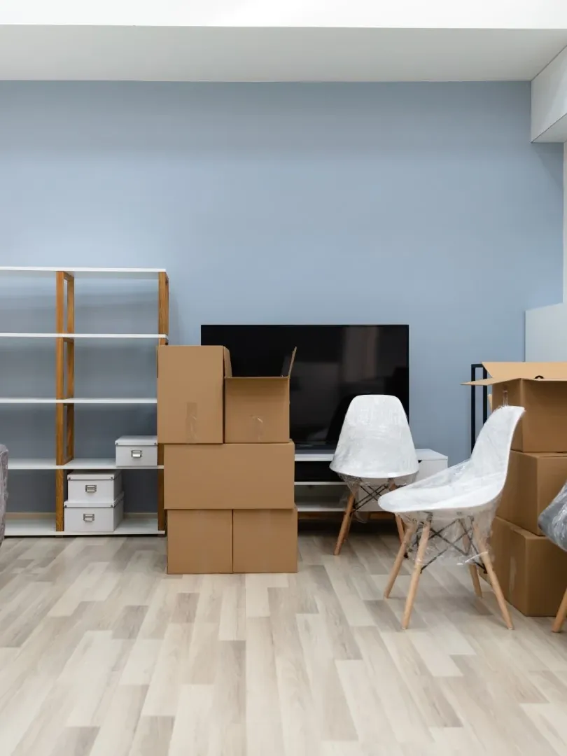 Wohnzimmer mit verpackten Möbeln und Umzugskartons vor dem Umzug